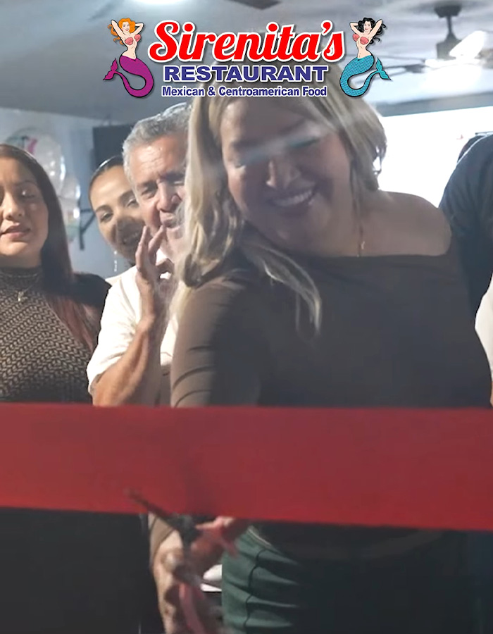 Group of people smiling during a ribbon-cutting at Sirenita's Restaurant serving Mexican and Centroamerican food.