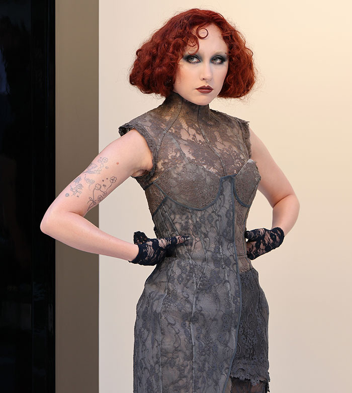 Chappell Roan posing in a lace dress with bold makeup, related to security guard controversy with Jude Law's daughter.
