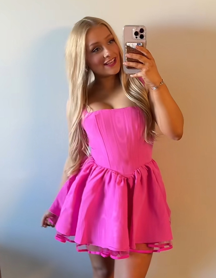 Cheerleader Laken Snelling taking a selfie in a pink dress, capturing moments for Snapchat history updates.