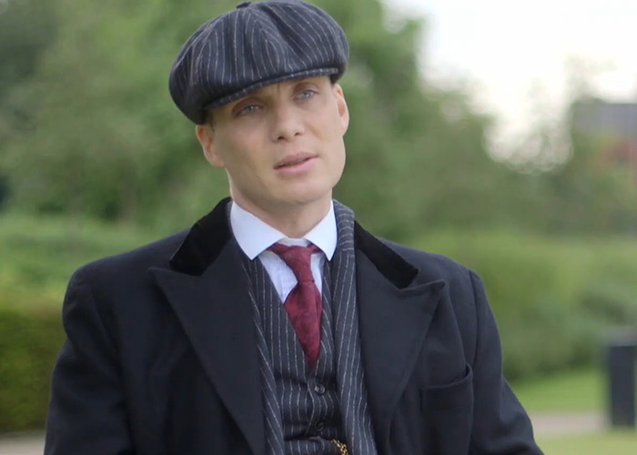 Cillian Murphy dressed in vintage attire outdoors, sparking debate over his appearance and how he has aged.