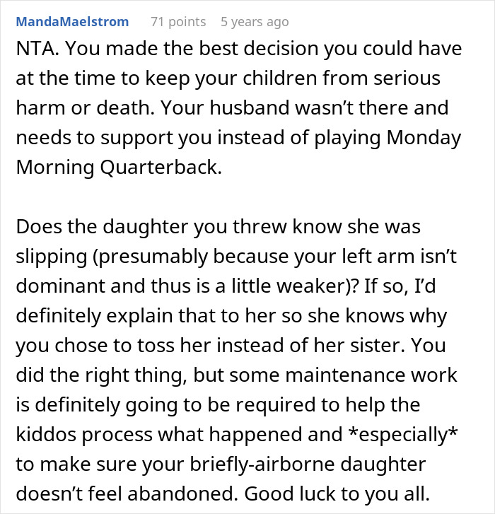 Wife holding twin girls near a fence as they are chased by a dog in a suburban backyard on a sunny day