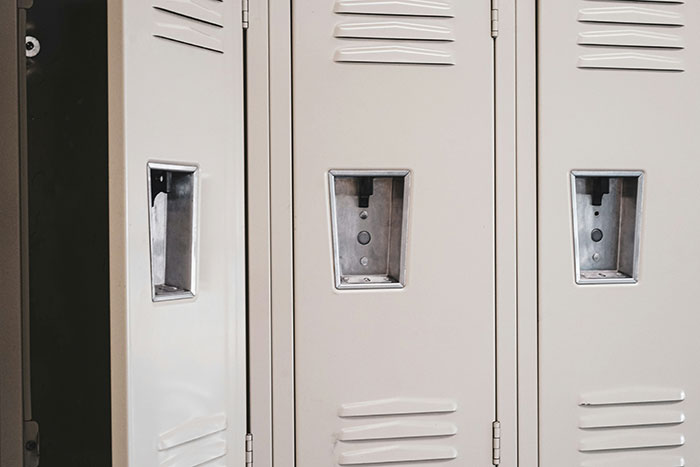 Empty beige lockers in a workplace setting symbolizing revenge to coworkers who deserved it and no one felt sorry.