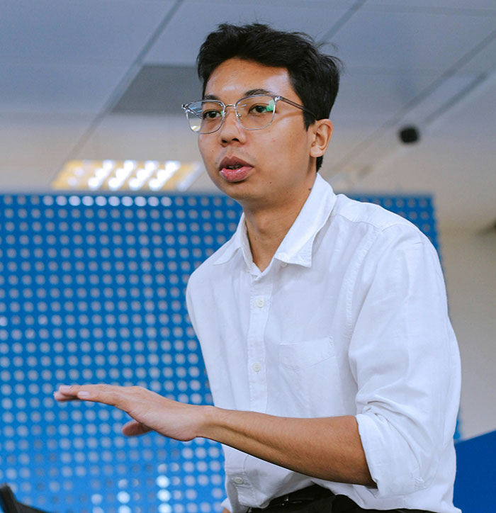 Young man in glasses explaining ideas in office, illustrating coworker revenge scenarios that no one felt sorry for.