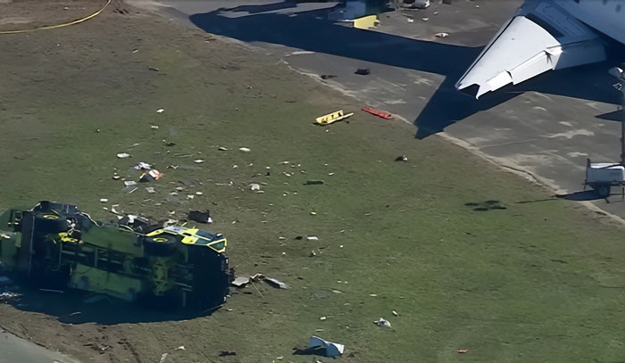 Especialistas em aviação examinam destroços do acidente da Air Canada LaGuardia com destroços espalhados e veículo de emergência capotado. Especialistas em aviação examinam destroços do acidente da Air Canada LaGuardia com destroços espalhados e veículo de emergência capotado.