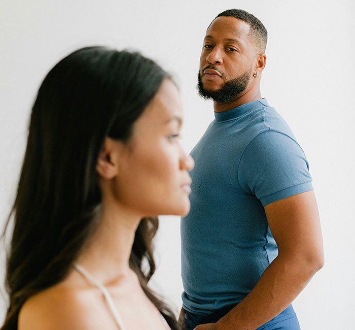 Couple in tense moment, man looking suspiciously at woman, illustrating stories of catching exes cheating.