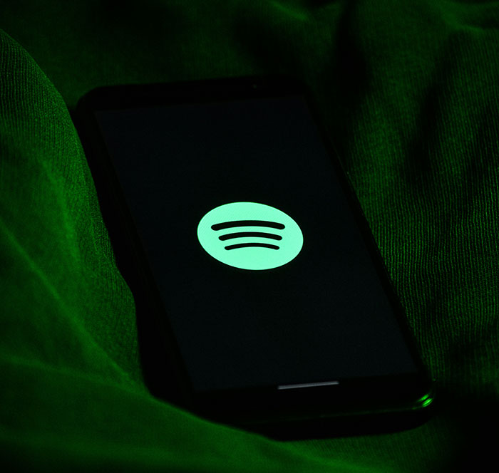 Smartphone displaying Spotify app logo on screen, symbolizing their Spotify used to catch exes cheating.