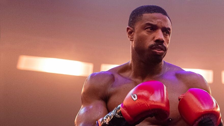 Michael B. Jordan in boxing gloves training intensely, showcasing strength and focus in upcoming movie roles after Oscar win