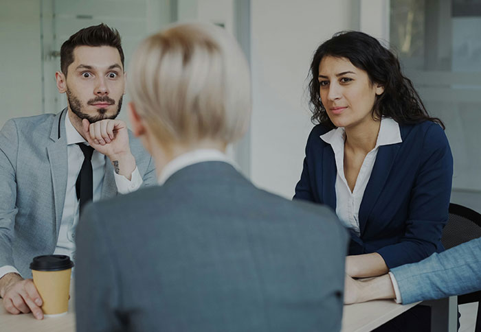 Two professionals display intense expressions during a meeting, showing the creepiest intelligence in a business setting.