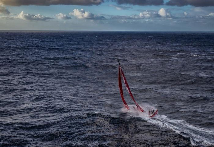 Sailboat navigating rough ocean waters under a cloudy sky, highlighting the vast and mysterious ocean environment.