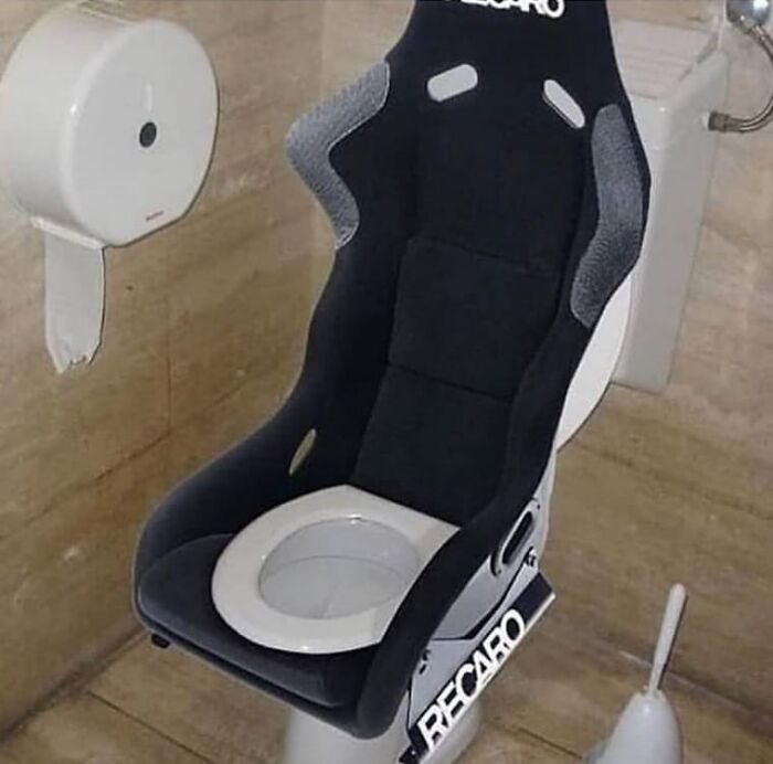 Racing car seat transformed into a toilet chair, creating a weird and cringey photo difficult to look at.