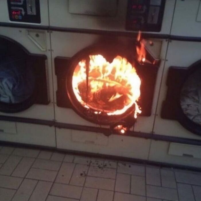 Washing machine fire with flames bursting out of the door, a cringey and weird photo difficult to look at.