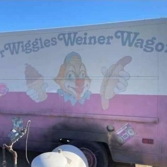 Faded clown holding ice cream and hot dog on a truck, creating a weird and cringey photo difficult to look at.