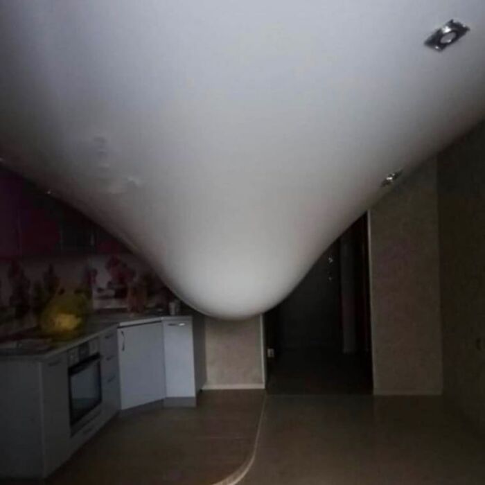 Distorted ceiling in a kitchen creating a weird and cringey visual effect, hard to look at unusual photo.