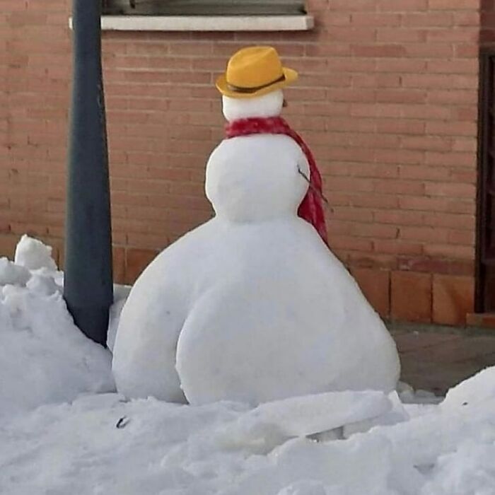 Snowman with an unusual shape wearing a yellow hat and red scarf, one of the weird and cringey photos difficult to look at.
