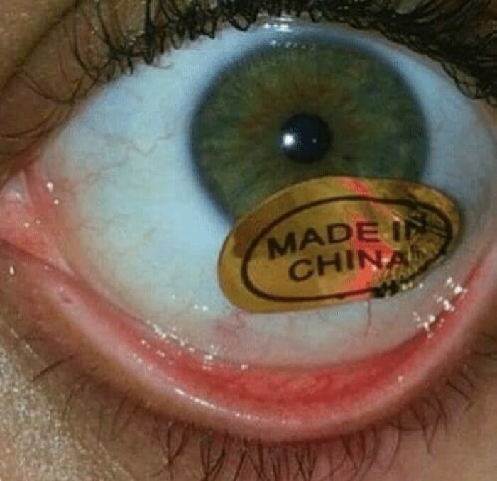 Close-up of an eye with a weird and cringey Made in China sticker stuck to the lower eyelid.