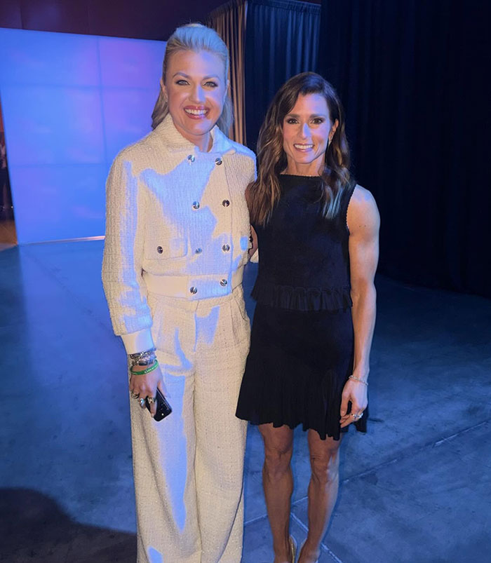 Danica Patrick posing with a fan at an event, highlighting strength and resilience of F1 drivers controversy.