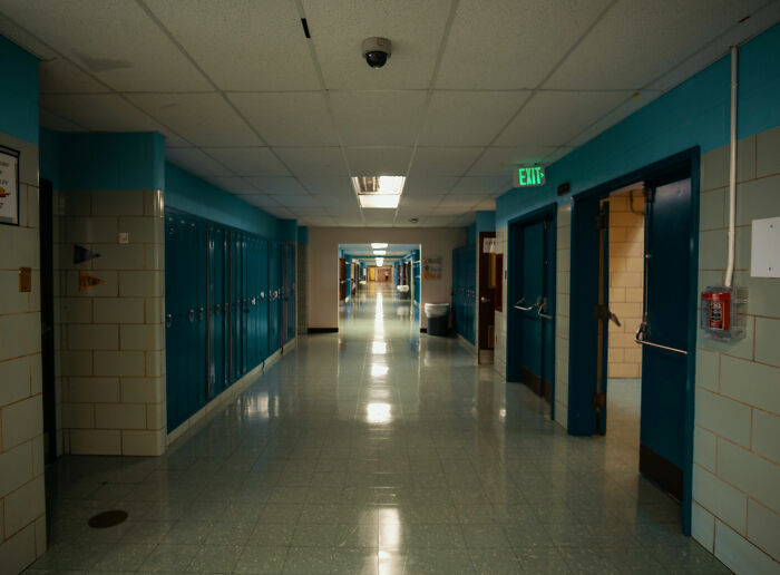 Empty school hallway with lockers and classroom doors, reflecting typical California teacher suspended incident setting.
