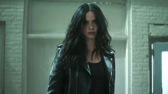 Woman with long dark hair wearing a black leather jacket in a dimly lit room, related to Daredevil Born Again Season 2.