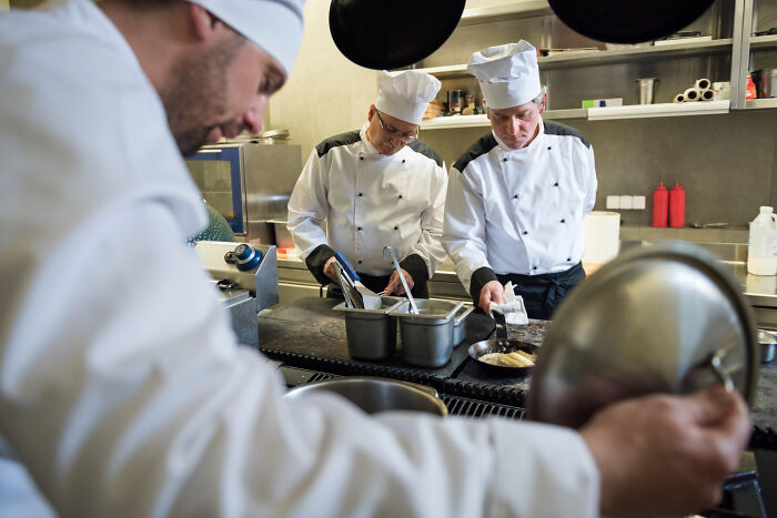Chefs working in a busy commercial kitchen revealing dark industry secrets behind the culinary facade.