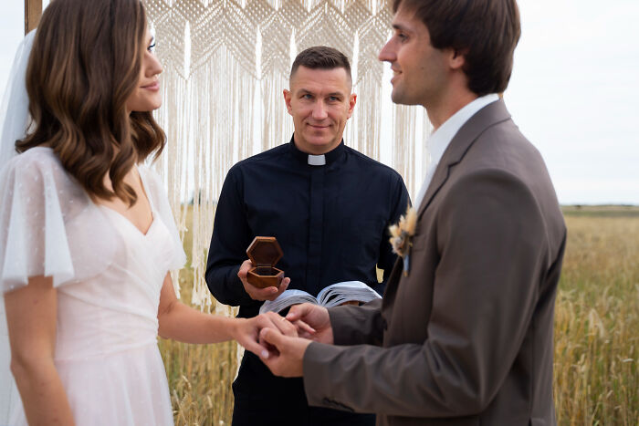 Couple exchanging rings outdoors with a priest officiating, symbolizing trust amidst dark industry secrets revealed by insiders.