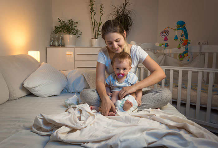 Teen daughter with baby in bedroom, highlighting family crisis and eviction due to new baby arrival at home.