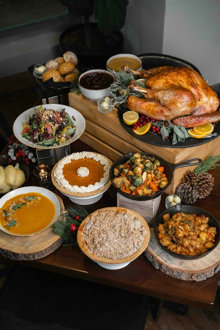 A festive holiday feast with roasted turkey, pies, soup, salad, and various side dishes representing weird family traditions.