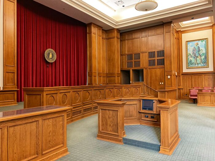 Empty courtroom with wooden panels and furniture representing shaky industries that can collapse anytime revealed