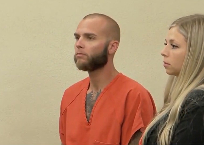 Woman allegedly allowing boyfriend to harm her young son with 46 injuries stands in court with man in orange jumpsuit.