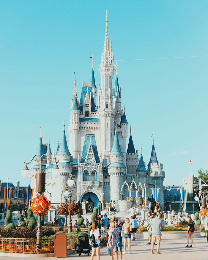 Disney World castle with visitors in front, related to influencer speaking out after inappropriate outfit complaints.