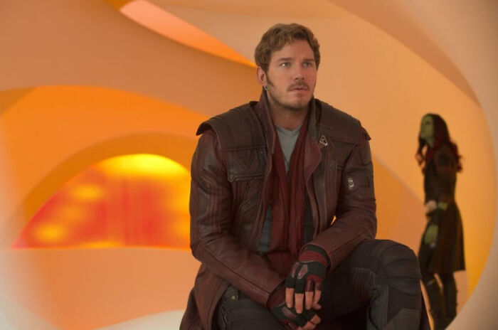 Actor sitting in futuristic outfit with a serious expression, illustrating celebrities people used to like but now hate.