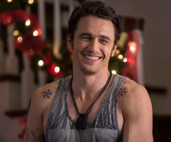 Young man with tattoos smiling in a casual setting, illustrating people confessing which celebrities they used to like but now hate.