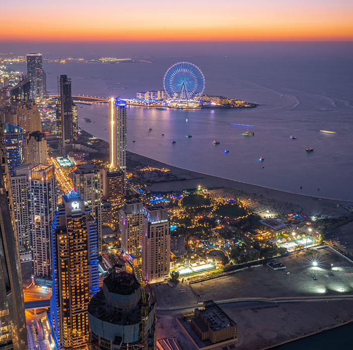 Nighttime aerial view of Dubai skyline and coastline, highlighting the contrast behind Dubai labor camps reality exposed in viral video.