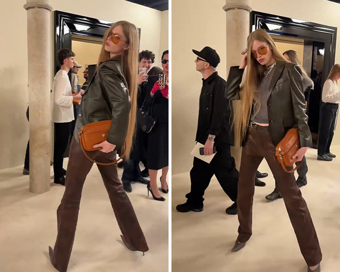 Elon Musk&rsquo;s estranged daughter posing at Paris Fashion Week in stylish leather outfit and orange sunglasses.