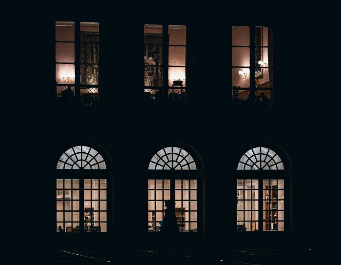 Night view of an American building with illuminated windows showing interior details, illustrating real American things seen in movies.