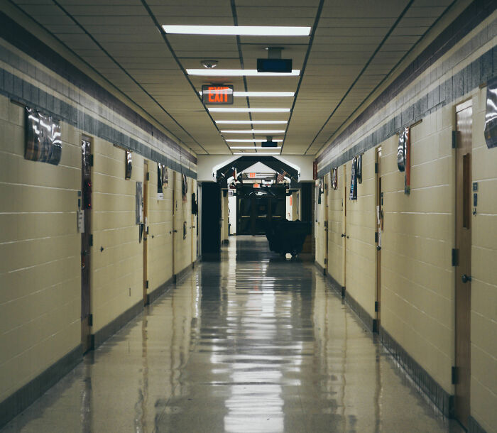 Empty middle school hallway with closed doors and overhead lights, related to middle school secretary vanishing case.