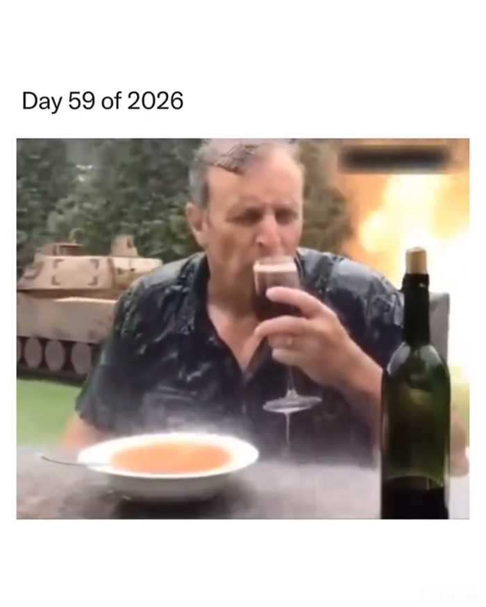 Man drinking wine by a bowl of soup with a tank and explosion in background, capturing WW3 angst in meme form.