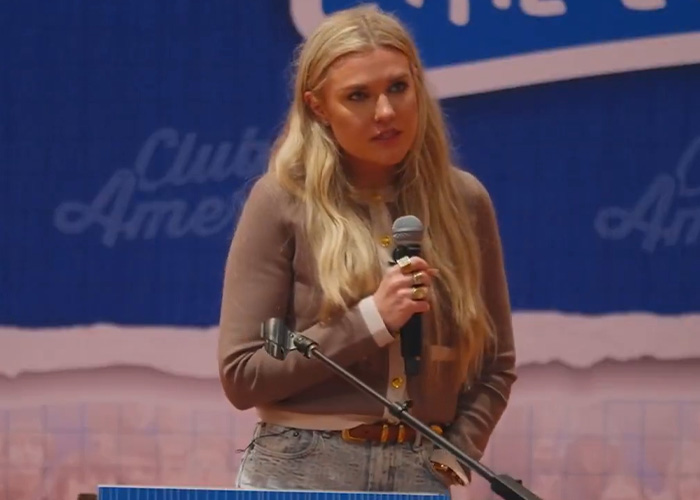 Erika Kirk speaking at an event, holding a microphone, addressing allegations involving her kids and Charlie&rsquo;s legacy.