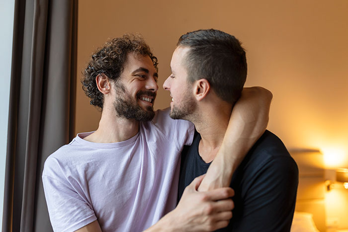 Two men embracing and smiling at each other, capturing a tender moment in a love story reconnecting with an ex.