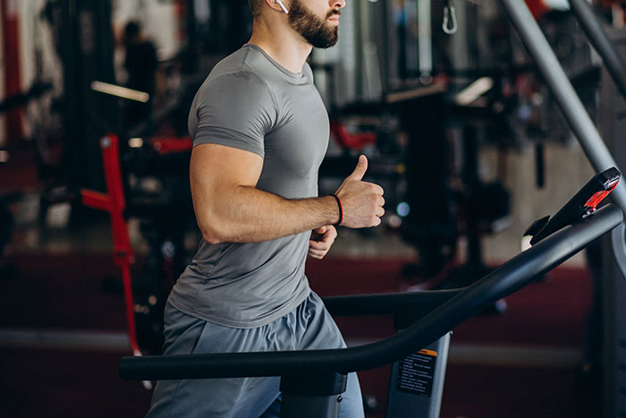 Man running on treadmill indoors, symbolizing a story of love and reconnecting with an ex he never stopped thinking about.