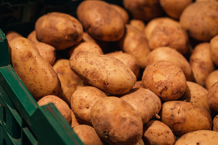 Close-up of a crate filled with fresh potatoes representing customer complaints making it hard for employees to keep a straight face.