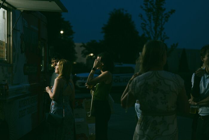 People standing outside at night near a food truck, illustrating sobering stories of ruined lives and personal struggles.