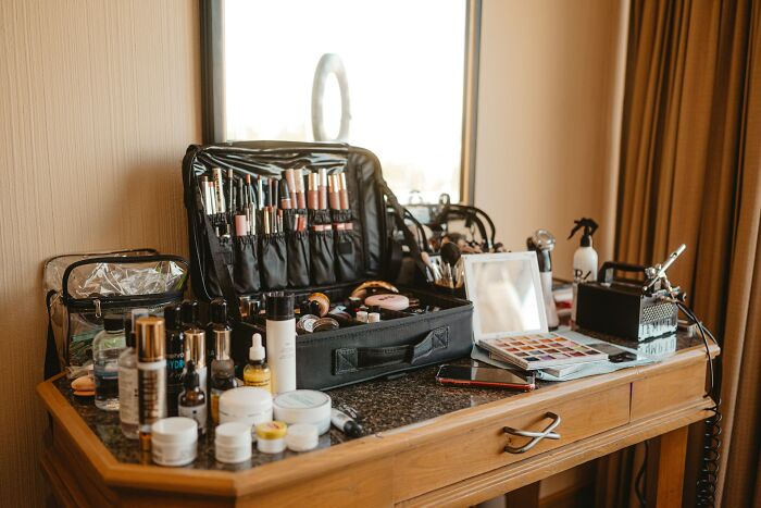 Makeup and beauty industry tools and products arranged on a wooden vanity highlighting shaky industries at risk of collapse.