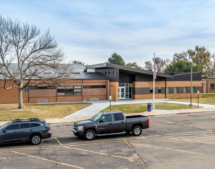 Front view of middle school building with parked cars in lot, related to middle school secretary vanishes news.
