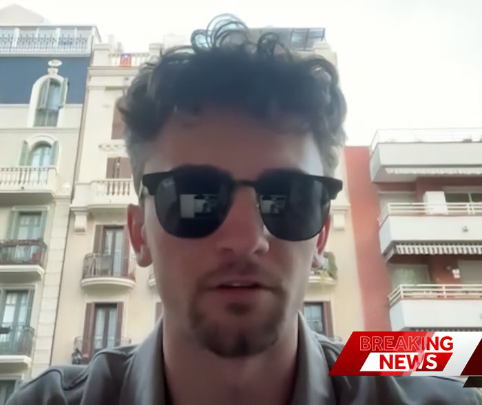 Young man wearing sunglasses in an urban setting with suspicious footage related to mysterious vanishing of American student in Spain.
