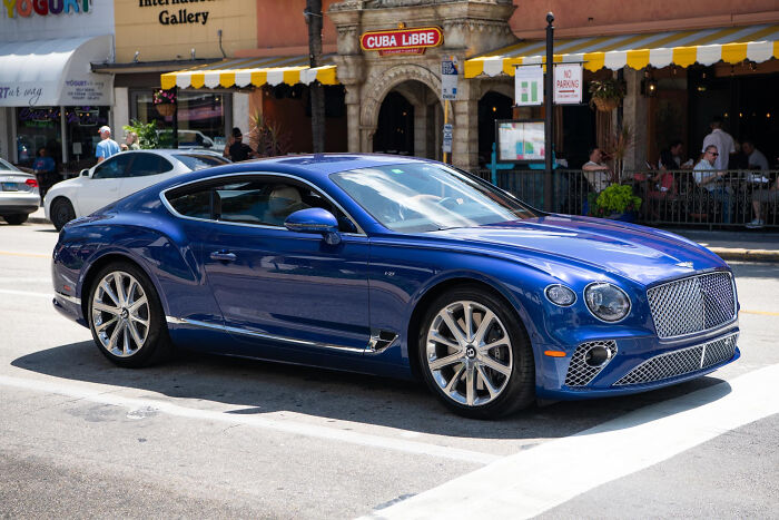 Blue luxury sports car parked on a city street, illustrating unusual moments funeral directors still remember.