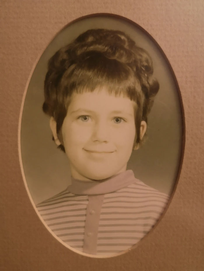 Childhood photo of a smiling child with a vintage hairstyle showing a classic hair disaster from the past.