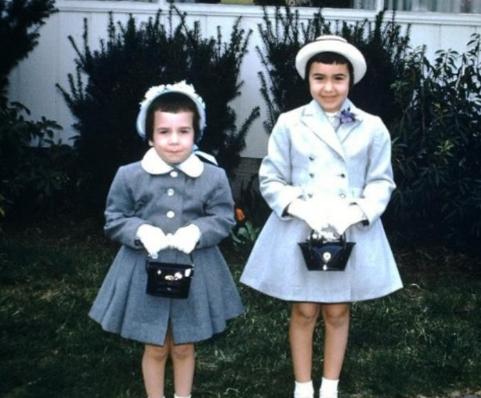 Two children in vintage coats and hats posing outdoors, showing childhood hair disasters with short, uneven hairstyles.