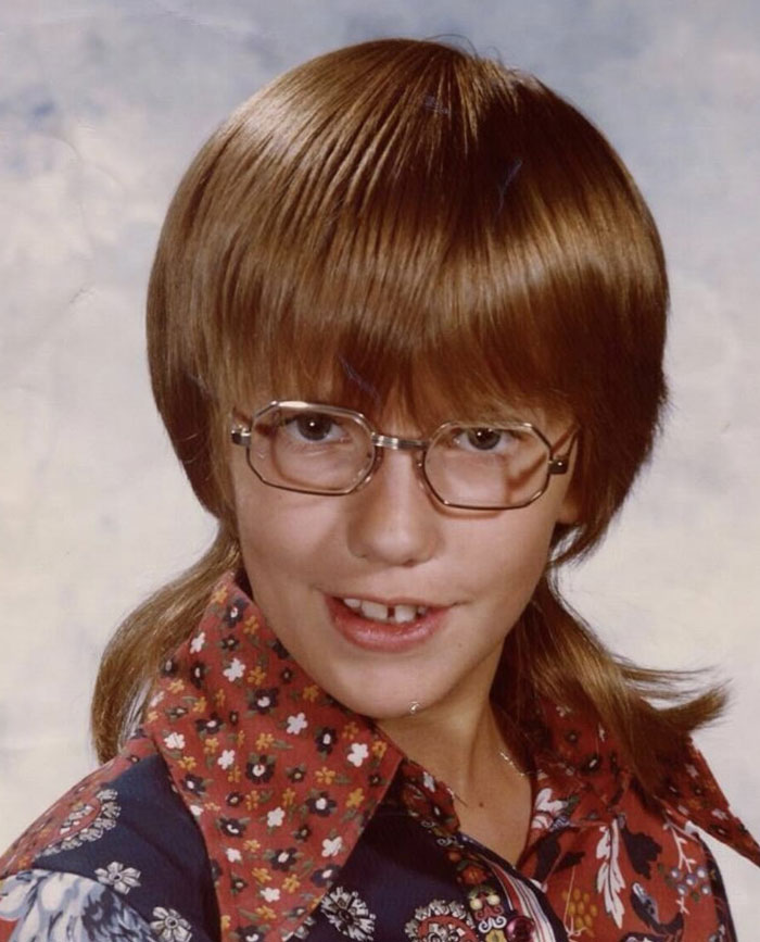Childhood photo showing a hair disaster with a mullet haircut and large glasses, capturing a vintage awkward hairstyle moment.