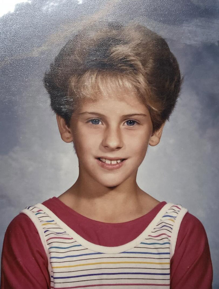 Child with a thick, voluminous hairstyle from childhood showing a classic hair disaster in a school photo.