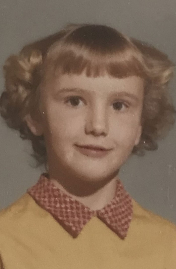 Childhood photo of a young girl with a unique haircut showing a classic hair disaster from the past.